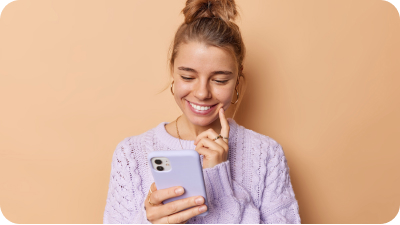 mujer sonriendo y mirando su celular