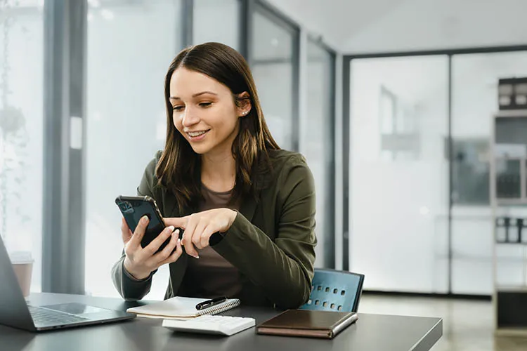 Mujer trabajadora revisando su celular