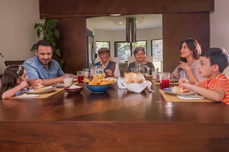 Familia feliz comiendo en la mesa