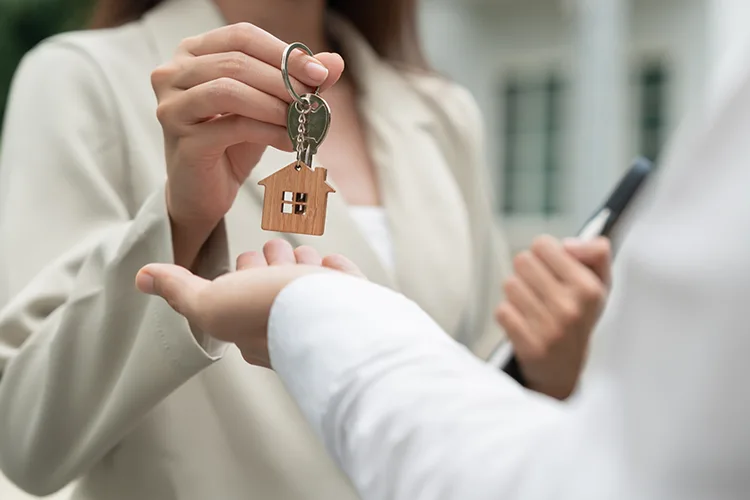 Mujer recibiendo llaves de casa propia