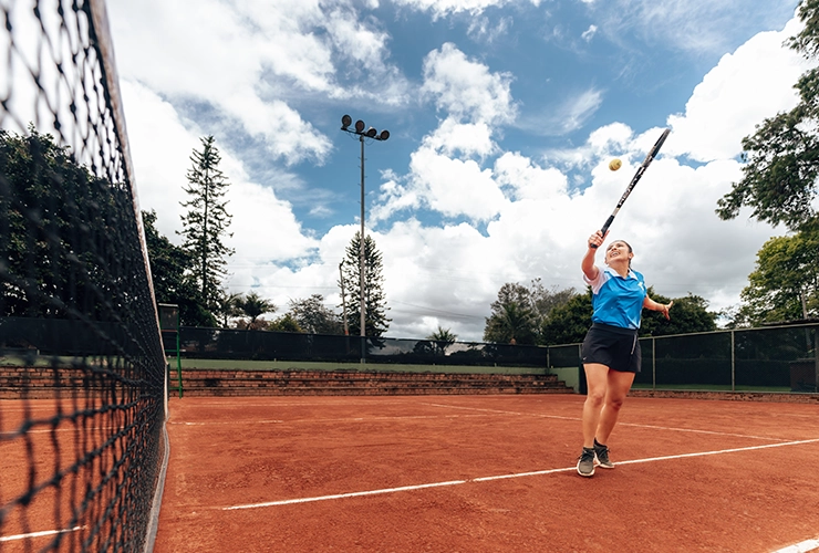 Mujer en clases semipersonalizadas de tenis de campo