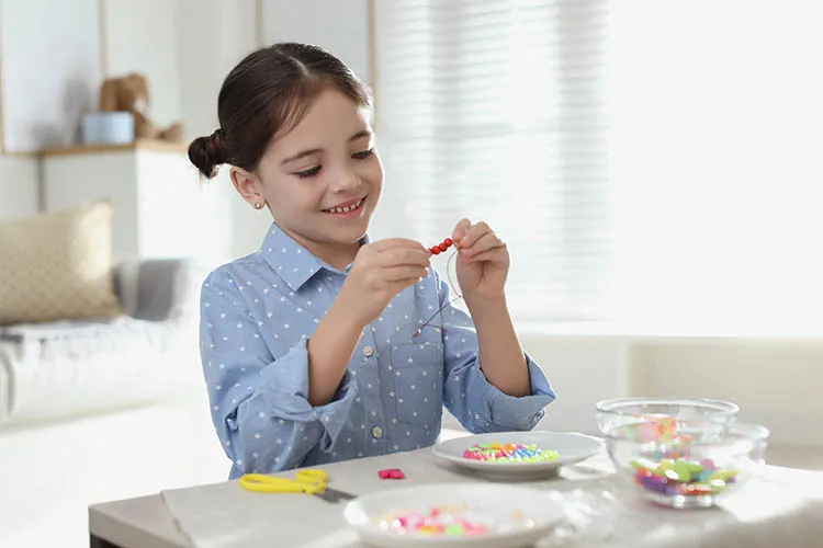 Niña haciendo bisutería