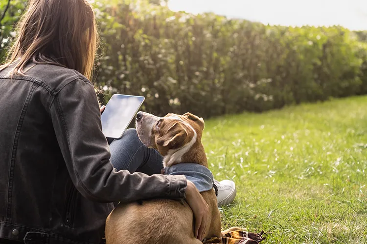 Mujer con su mascota revisando su tablet