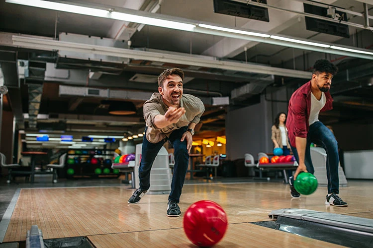 Personas haciendo el deporte de bolos Colsubsidio