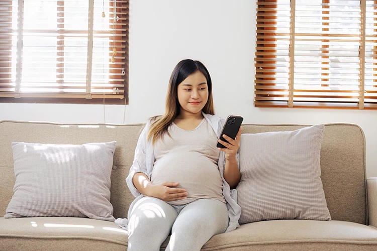 Mujer embarazada mirando celular