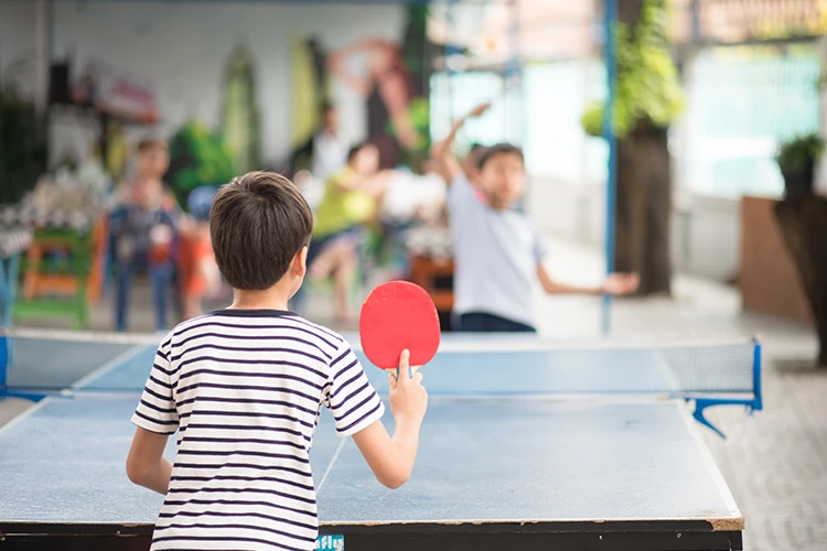 Niños jugando tenis de mesa