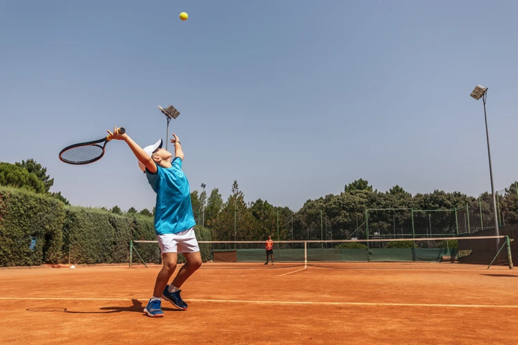 Niño jugando tenis de campo