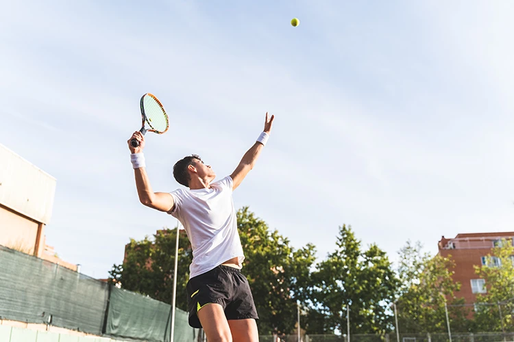 Joven jugando tenis de campo