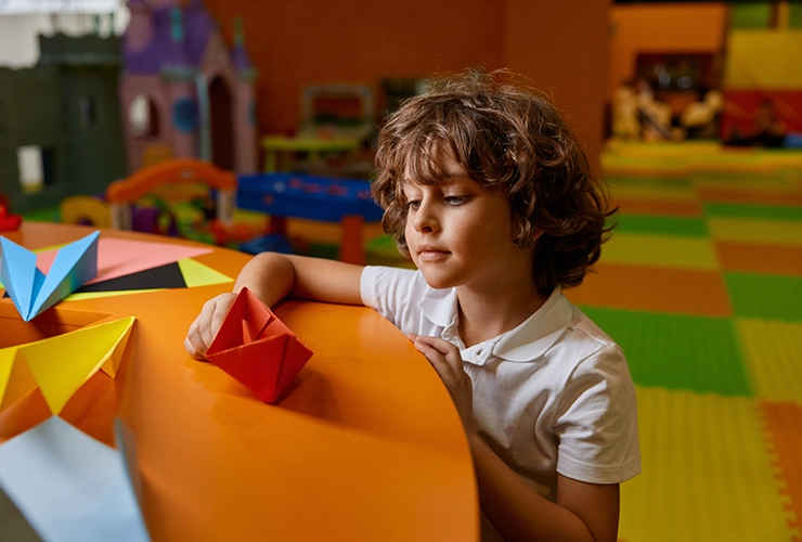 Niño con barquito de papel