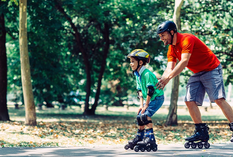 Hombre enseñándole a niño a montar patines