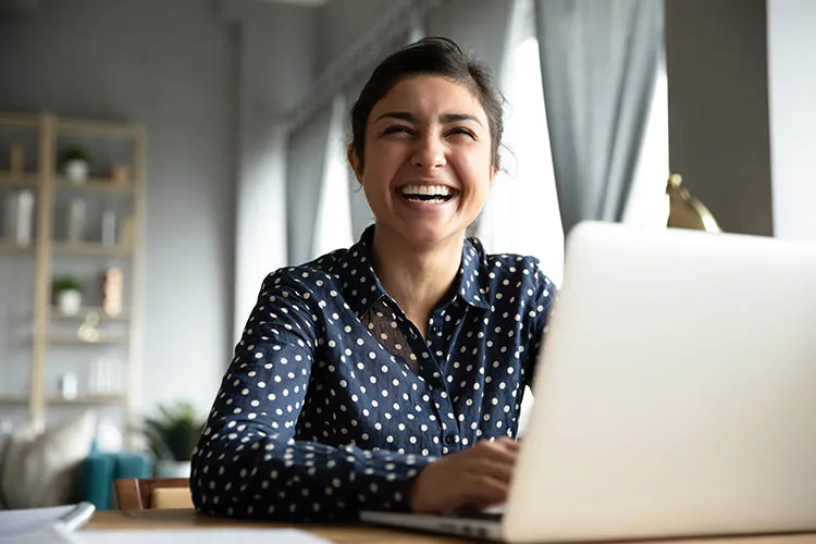 Mujer sonriendo frente al computador