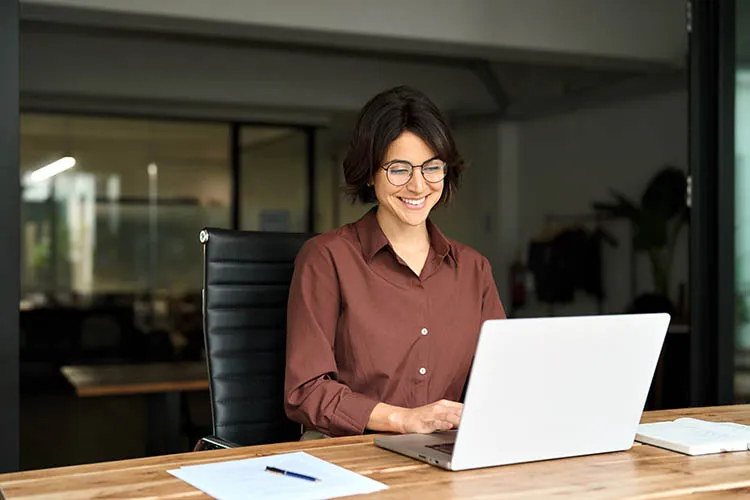 Mujer sonriendo frente al computador