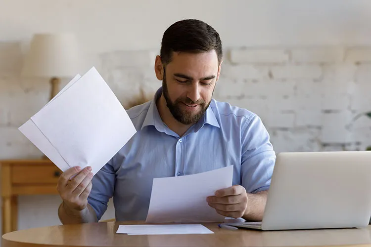 Hombre en escritorio revisando papeles