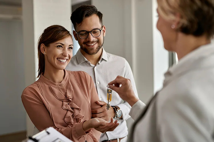 Pareja recibiendo las llaves de su casa nueva