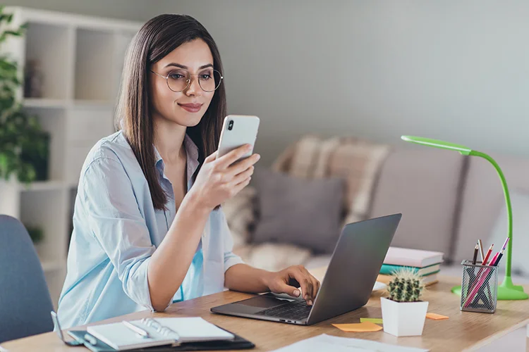 Mujer mirando celular y trabajando