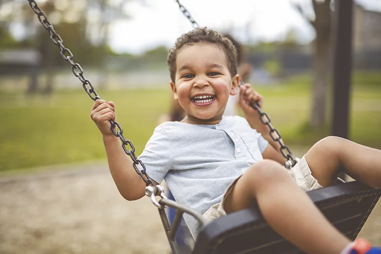 Niño feliz en columpio