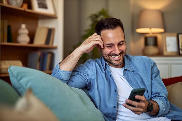 Hombre sonriendo y viendo el celular