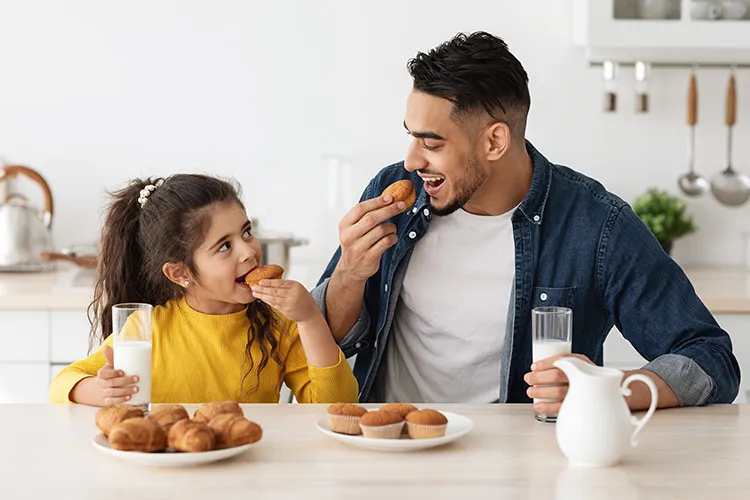 Niña con su padre utilizando en bono lonchera Colsubsidio