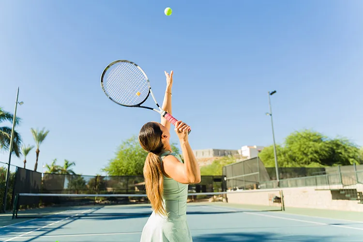 Mujer jugando tenis de campo