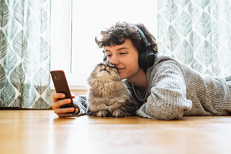 Niño mirando el celular acompañado de su mascota