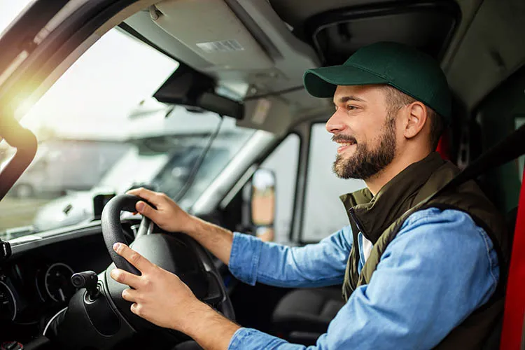 Hombre conduciendo y sonriendo