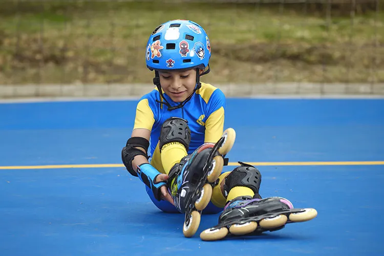 Niño abrochándose los patines 