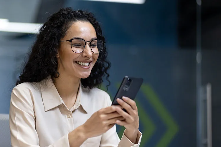 Mujer sonriendo viendo su celular