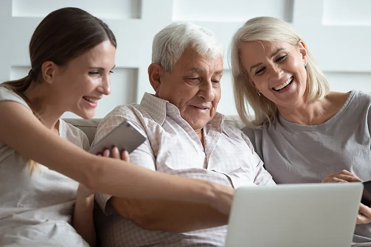 Familia con adulto mayor frente a un computador