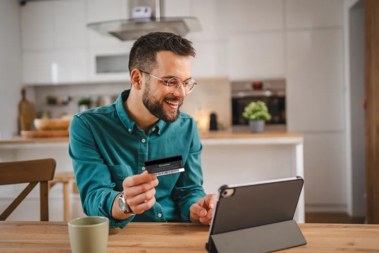 Hombre sonriendo con su tarjeta de afiliación Colsubsidio