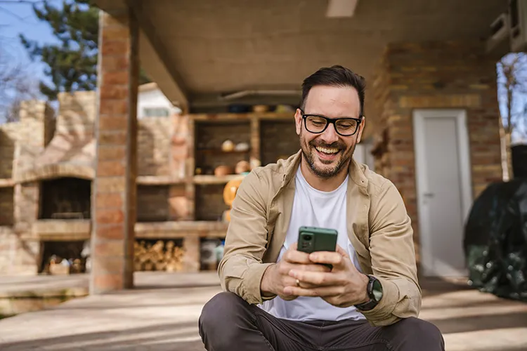 Hombre sonriendo y mirando el celular