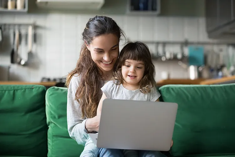 Madre con su hija revisando el computador