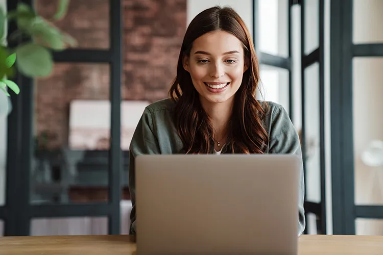 Mujer frente al computador sonriendo