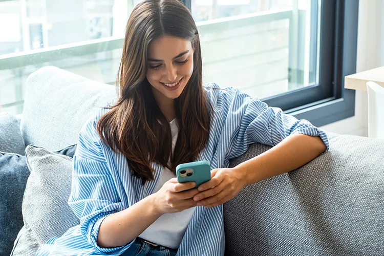 Mujer sonriendo y viendo el celular