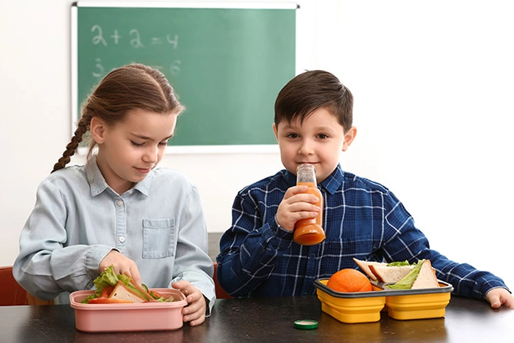 Niños comiendo de su lonchera