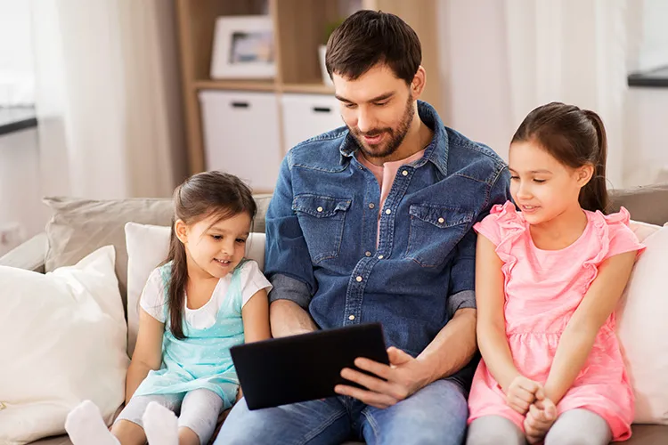 Padre con sus hijas revisando la tablet