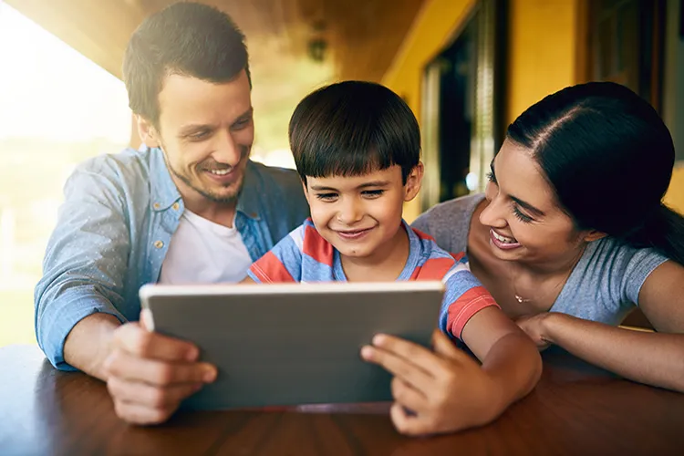 Padres con su hijo revisando la tablet