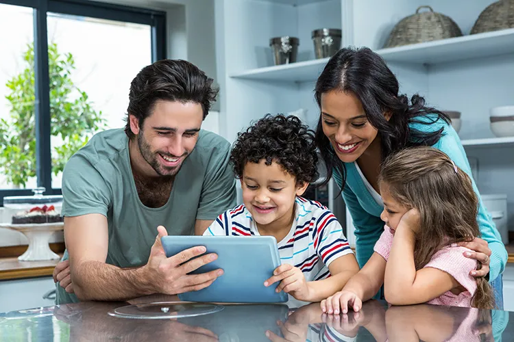 Padres con sus hijos revisando la tablet