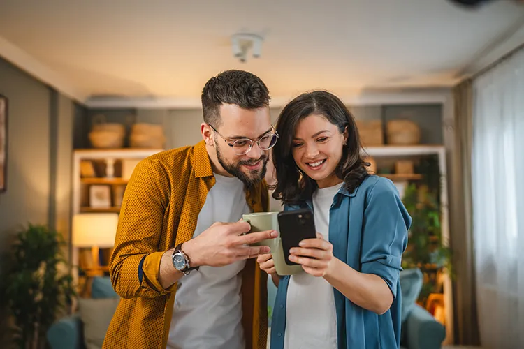 Pareja sonriendo y viendo el celular