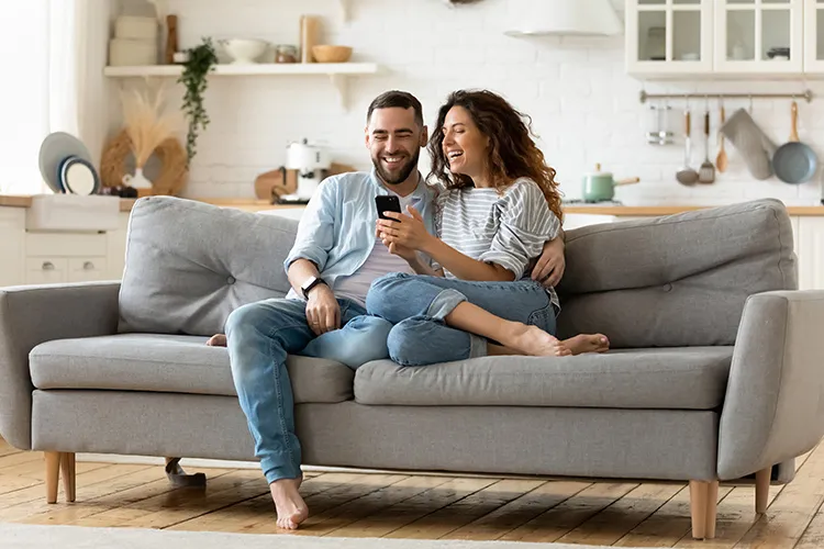 Pareja sonriendo frente a su celular