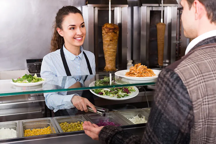 Personas en bufet de comida