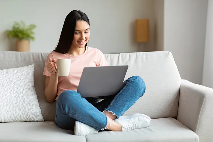 Mujer alegre leyendo en su computador