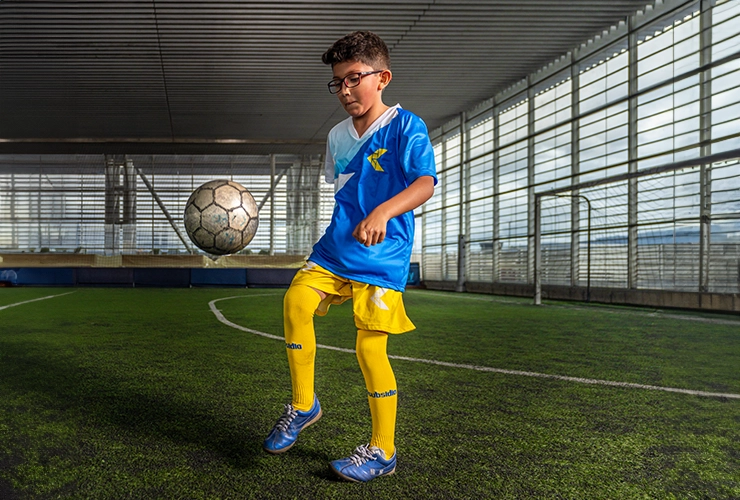 Niño jugando en escuela deportiva de fútbol