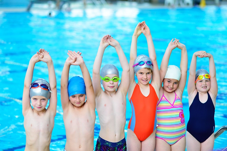 Niños afuera de piscina en etapa aprendiendo los estilos