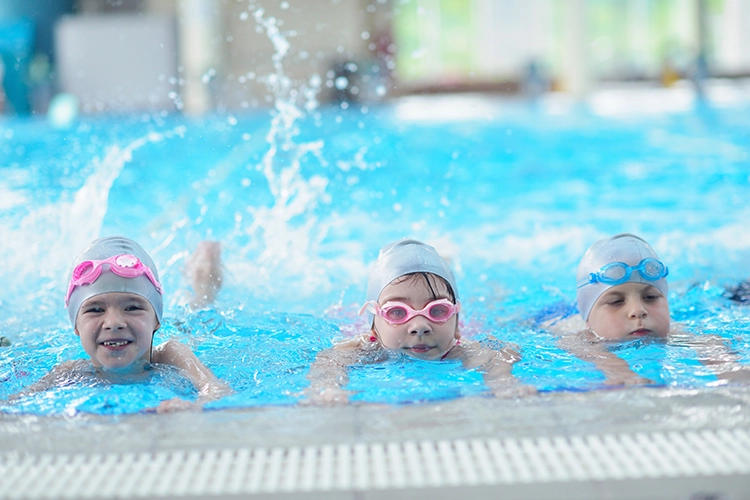 Niños en piscina en etapa técnica avanzada de natación