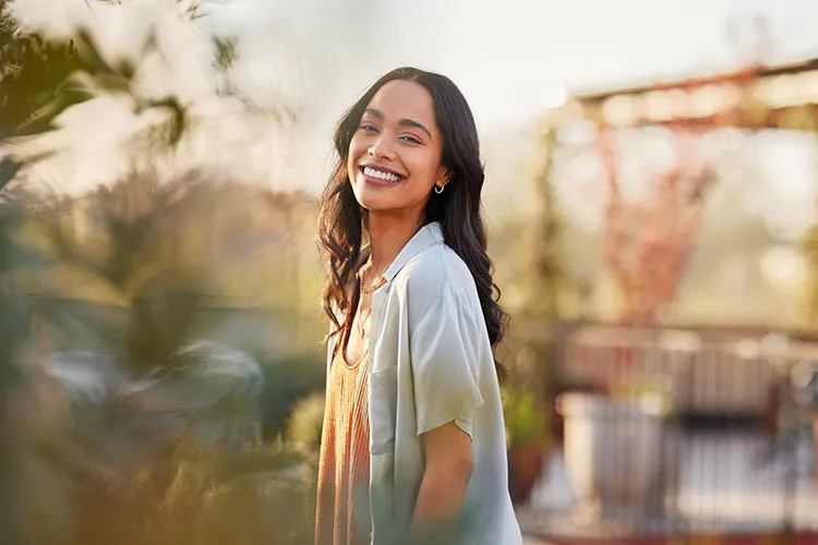 Mujer sonriendo por mejora continua