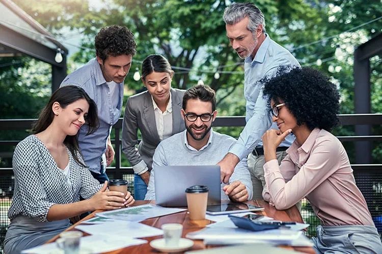 Personas reunidas alrededor de un computador