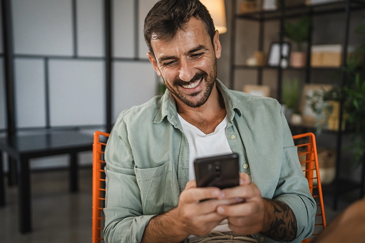 Señor sonriendo con el celular