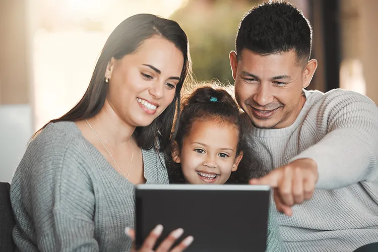 Familia mirando su Tablet y sonriendo