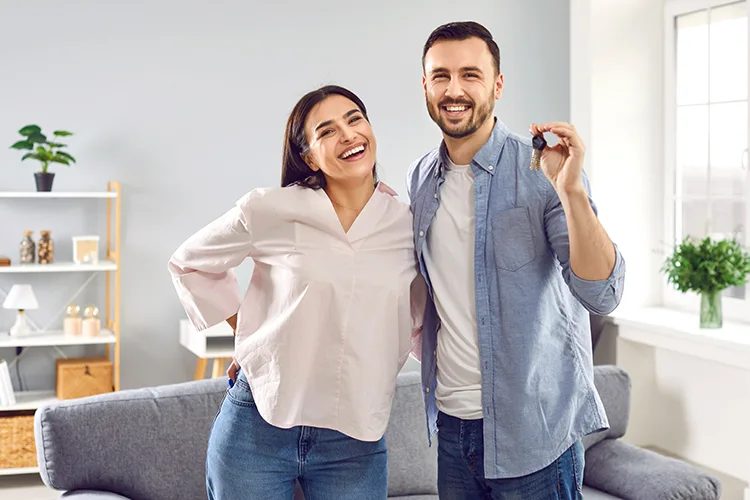 Pareja feliz con llaves de su nueva casa