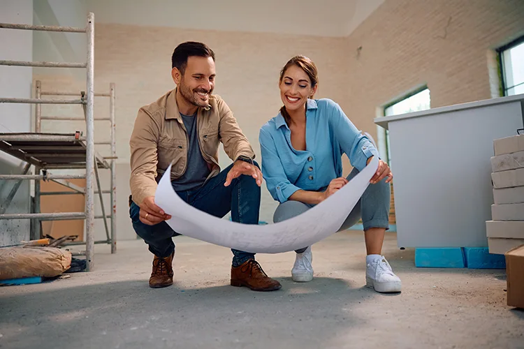 Hombre y mujer mirando planos para mejoramiento de vivienda